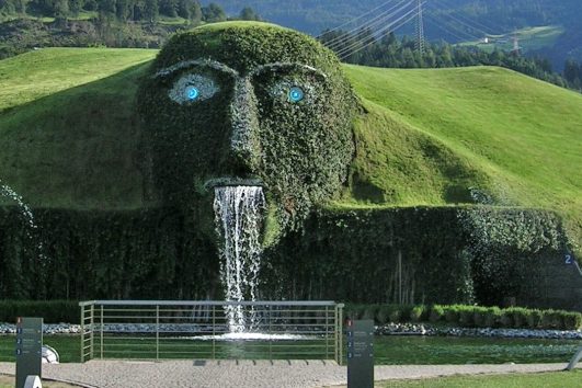 Giant grass-covered face sculpture with waterfall at Swarovski Crystal Worlds, Wattens, Austria